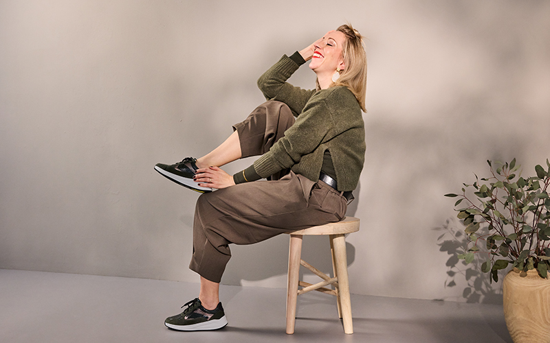 Solidus Kitty 54501 Damen-Sneaker in Farbe 30762 – Lifestyle-Motiv mit lachender Frau auf Hocker, leichte weiße Sohle und modischer Look