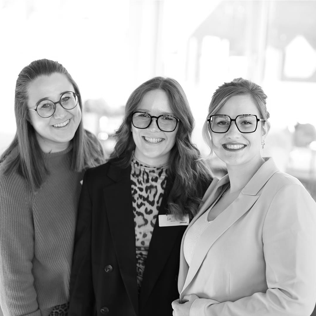 Solidus Teamfoto: drei Mitarbeiterinnen lächeln in die Kamera, Schwarzweiß