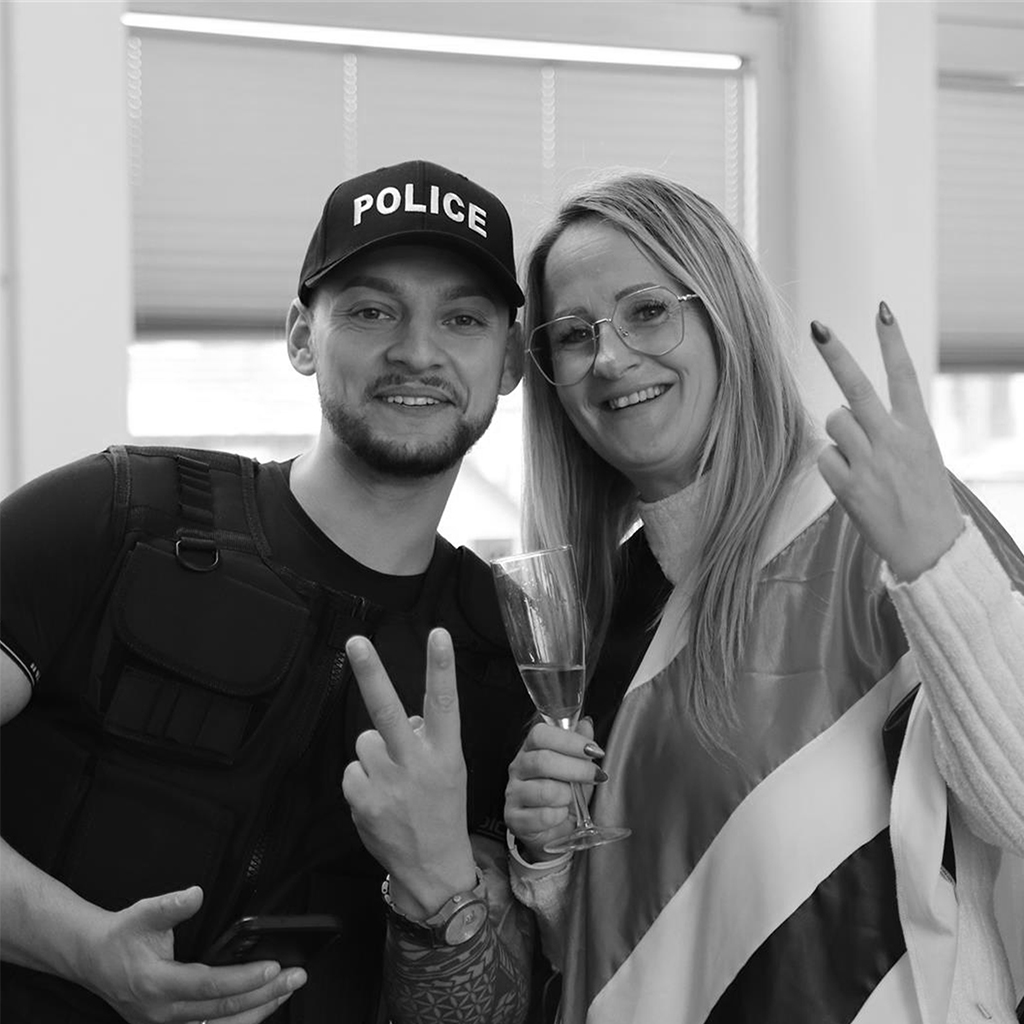 Zwei Mitarbeitende posieren in Kostümen, machen Peace-Zeichen, Schwarzweiß