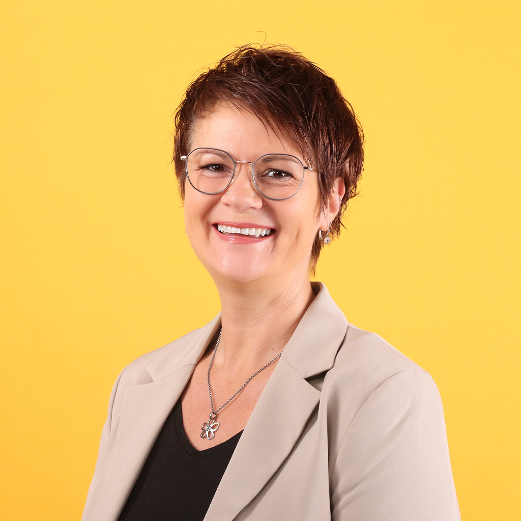 Porträt von Katja Degenkolb, Mitarbeiterin bei Solidus, vor gelbem Hintergrund