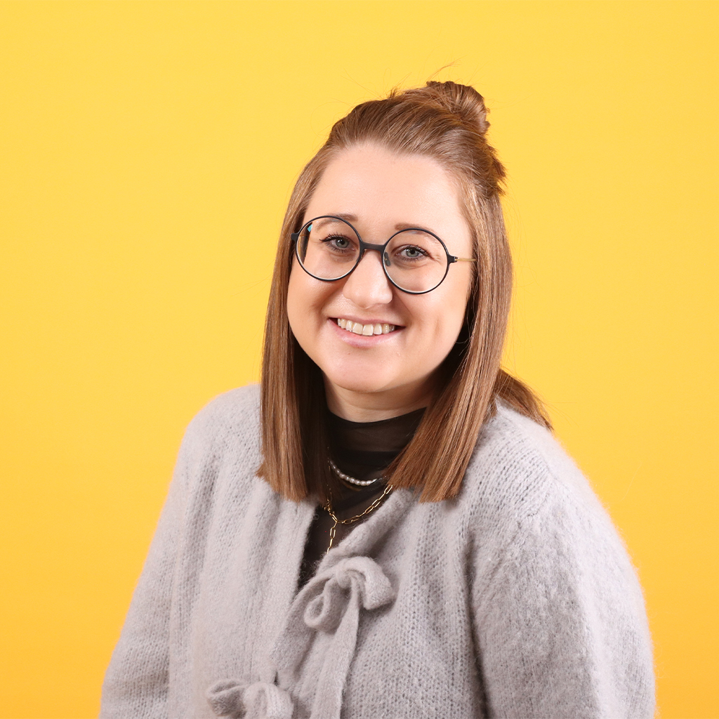 Porträt von Elisa Möst, Mitarbeiterin bei Solidus, vor einfarbigem Hintergrund