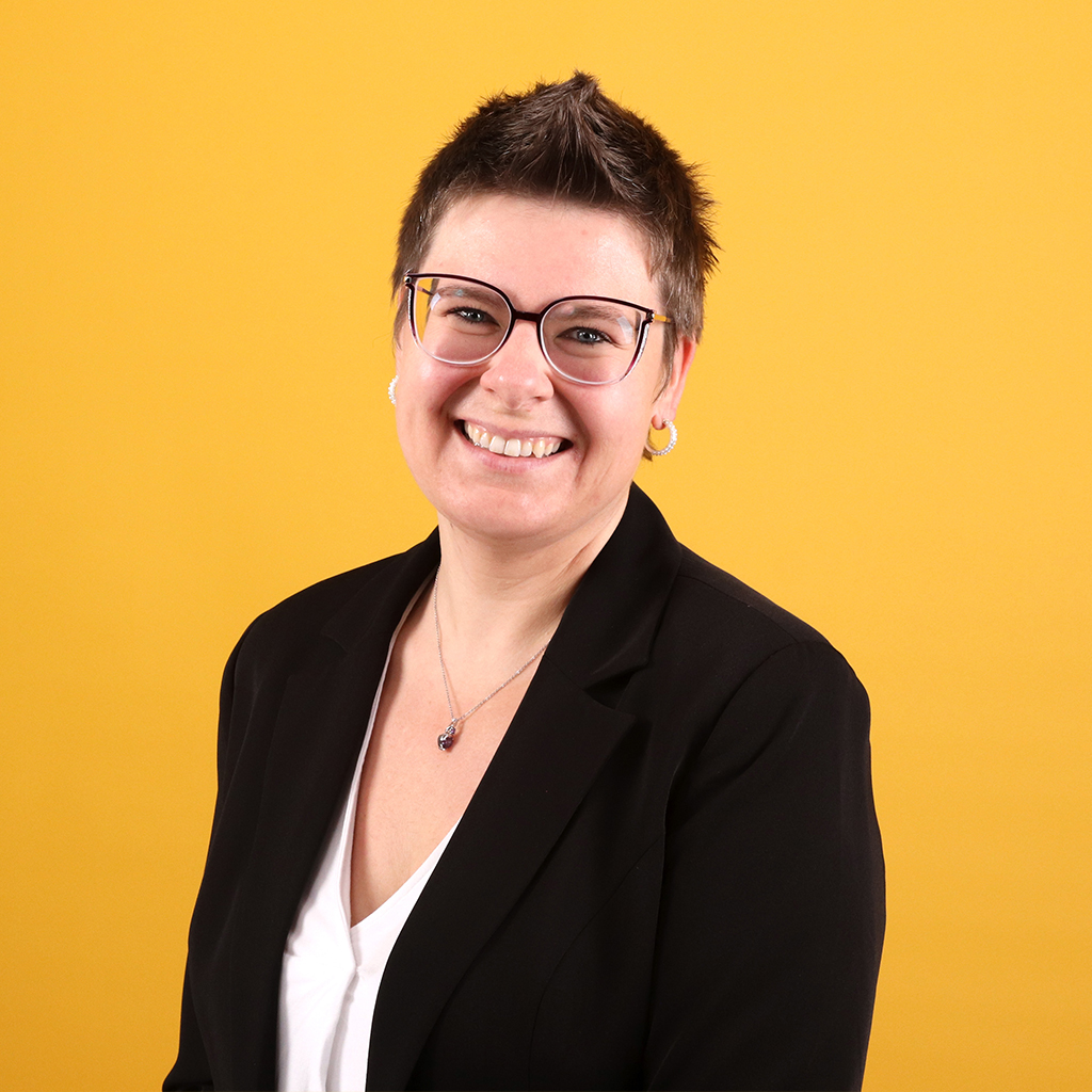 Porträt von Sandra Winkler, Mitarbeiterin bei Solidus, vor einfarbigem Hintergrund