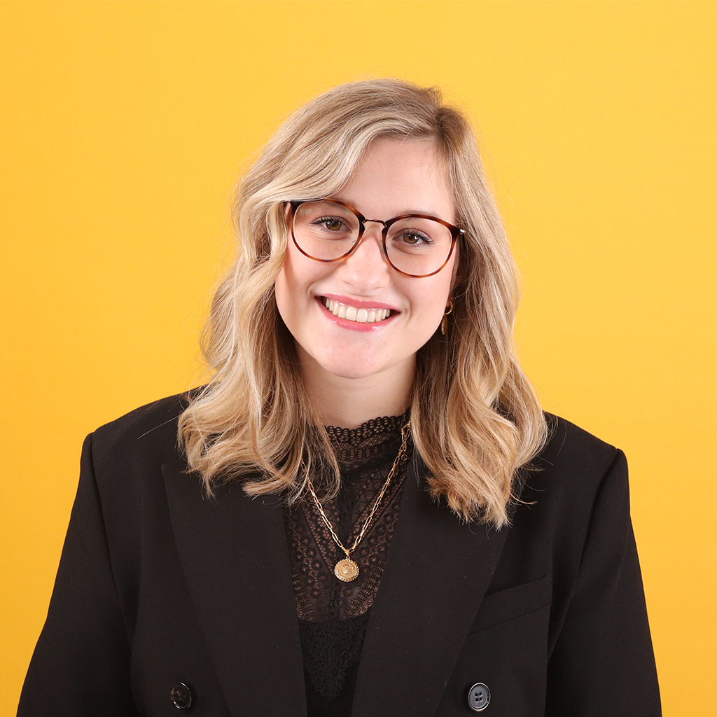 Porträt von Denise Strom, Mitarbeiterin bei Solidus, vor einfarbigem Hintergrund