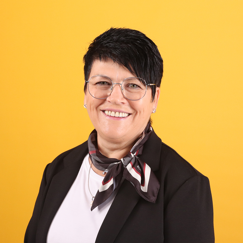 Porträt von Veronika Berwanger, Mitarbeiterin bei Solidus, vor einfarbigem Hintergrund