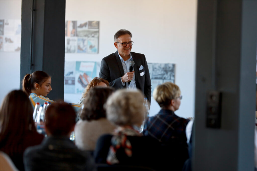 Vortrag bei der Solidus Academy: Uwe Decker mit Mikrofon spricht vor Teilnehmenden im Seminarraum