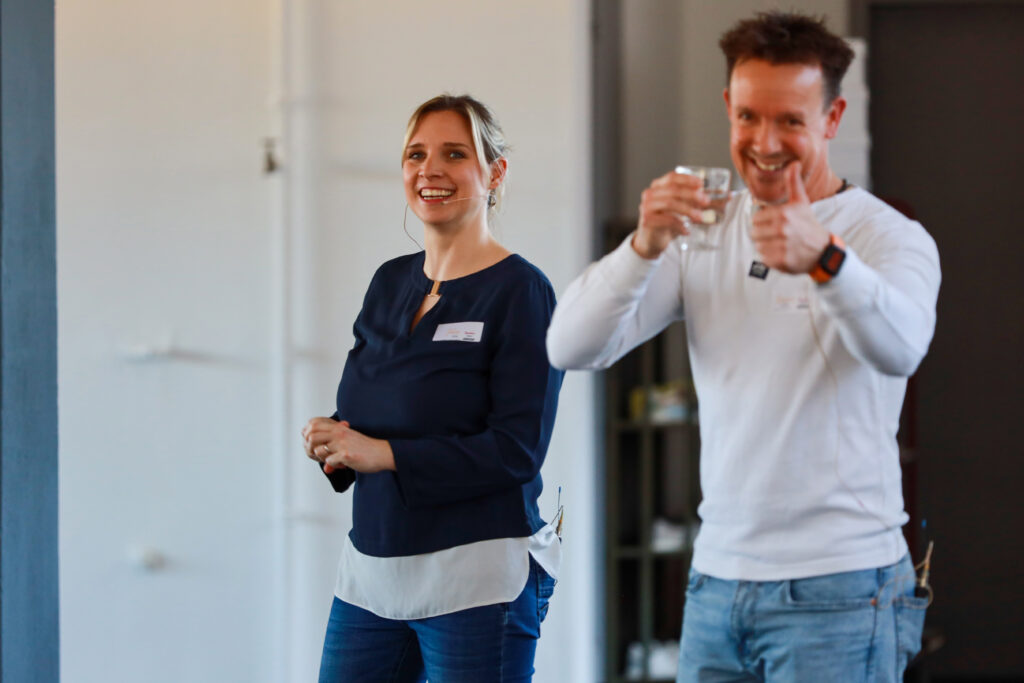 Referentinnen und Referent bei einem Solidus Workshop zur Bewegungstherapie, lächelnd im Seminarraum vor Teilnehmenden