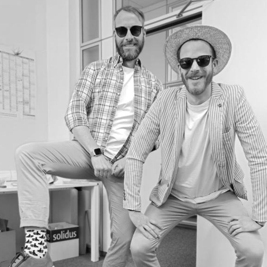 Michael Großmann bei der Solidus Academy 2023, schwarzweißes Foto mit Sonnenbrille und Hut vor dem Gebäude