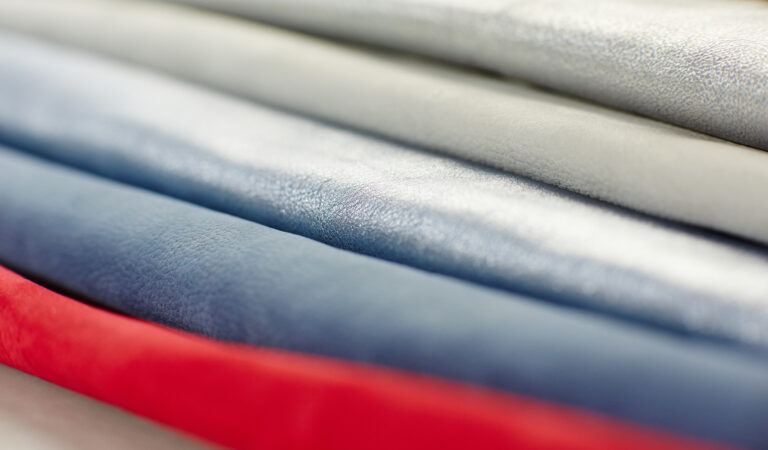 Nahaufnahme von Solidus Lederfarben: Rot, Blau und Metallic-Silber als Materialauswahl für die neue Kollektion